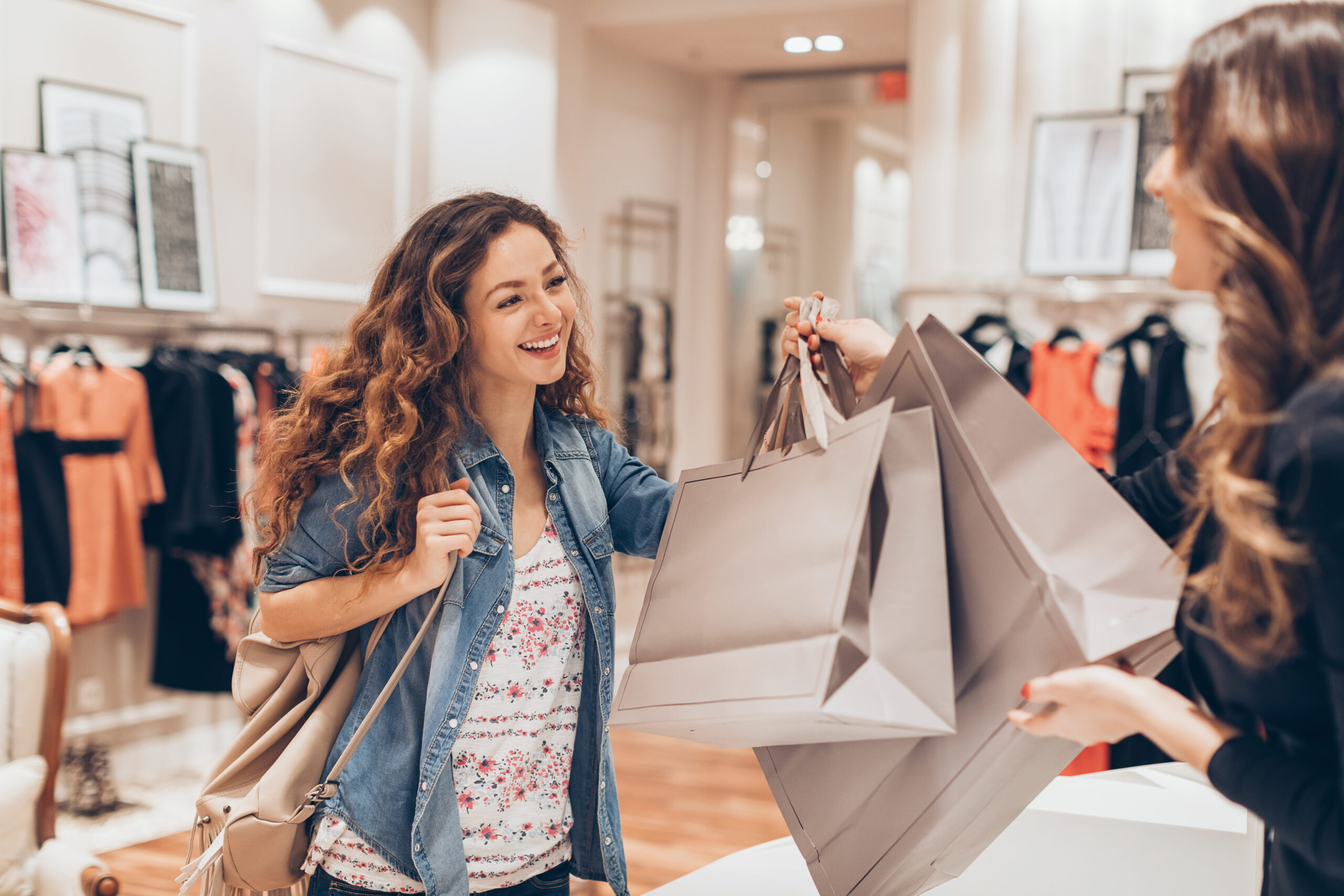Jeune femme prenant ses sacs de shopping dans un magasin de mode